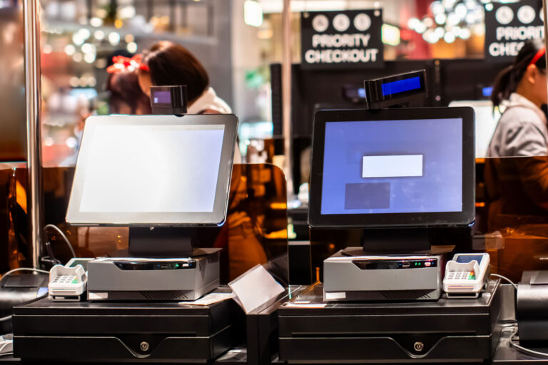 リユース市場の成長を加速させる!クラウドPOSシステム導入の全貌 3 リユース店舗に設置されたセルフレジ式のPOS端末の写真。前面にはタッチパネルやキャッシュドロア、クレジット端末などが並ぶ。