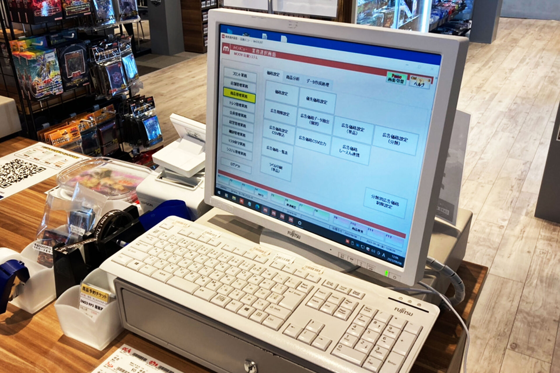 トレカショップ実店舗のカウンターに設置されたクラウドPOSシステムMOOVの利用シーン